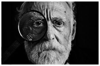 Man with a magnifying glass in front of his eye